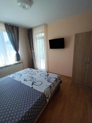 a bedroom with a bed and a flat screen tv at Guest rooms Bansko in Bansko