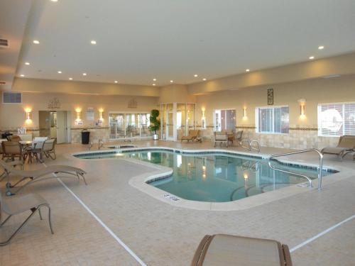 a large pool in a hotel with tables and chairs at Holiday Inn Express and Suites Alpine by IHG in Alpine