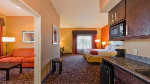 a hotel room with a bed and a couch at Holiday Inn Express and Suites Alpine by IHG in Alpine