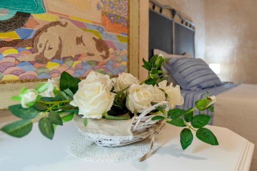 a vase of white roses sitting on a table at Lu Casal de Fiò in Alghero