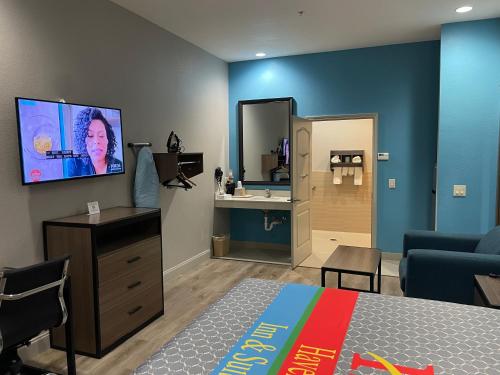 a room with a bed and a bathroom with a sink at Haven Inn & Suites Downtown Houston. in Houston