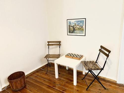 um quarto com duas cadeiras e uma mesa branca em Princess Amalia Vintage Apartment em Atenas