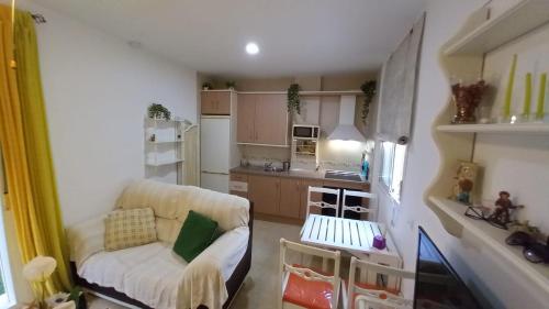 ein kleines Wohnzimmer mit einem Sofa und einer Küche in der Unterkunft Ático Roquetas in Roquetas de Mar
