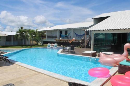 een zwembad met een roze flamingo in een huis bij Casa Alto do Cunhau in Barra do Cunhau