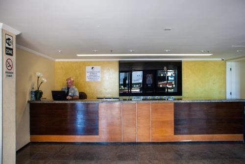 福塔莱萨Apartamento Praia de Iracema的坐在餐厅酒吧的女人