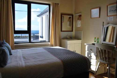 a bedroom with a bed and a large window at Teach Cruachan Bed and Breakfast in Dooagh