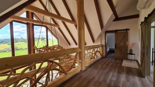 escalera de madera en una habitación con ventanas grandes en Chalet Liptov en Ižipovce