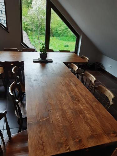 uma grande mesa de madeira num quarto com uma grande janela em The Millhouse Bled em Bled