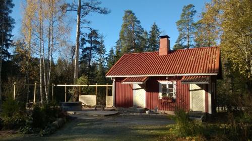 a small red house with a red roof at Villa Tammikko in Tuusula