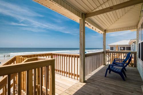 a porch with a blue chair on the beach at Absolute Beach by Oak Island Accommodations in Oak Island