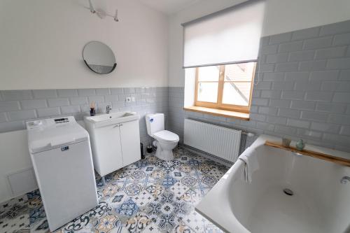 a bathroom with a tub and a toilet and a sink at Apartaments Nr. 33 ( Viesu Nr. 4) in Talsi