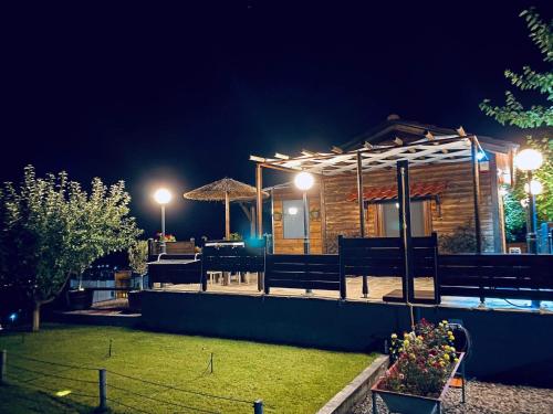 a log cabin at night with lights at ΛΩΤΟΣ in Kavala