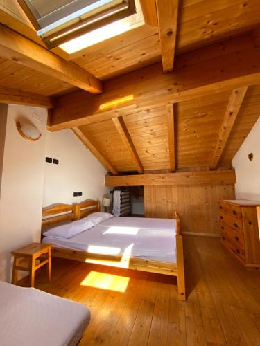 ein Schlafzimmer mit einem großen Bett in einer Holzdecke in der Unterkunft Casa Fiemme Panchià in Panchia