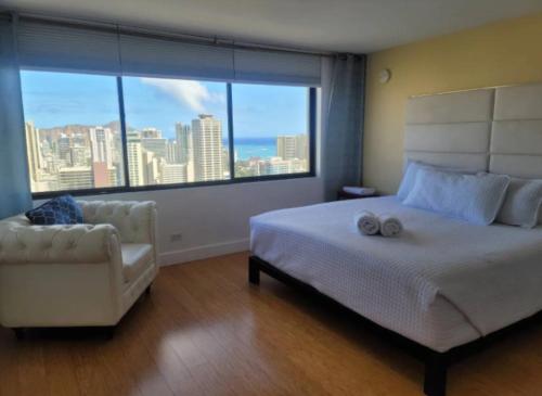 a bedroom with a bed and a chair and a large window at Apartment With Beautiful View in Hawaii in Honolulu