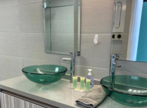 a bathroom with a green sink and a mirror at Apartment With Beautiful View in Hawaii in Honolulu