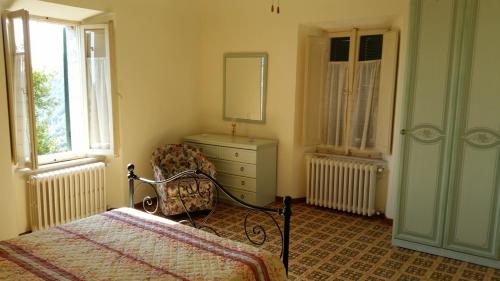 ein Schlafzimmer mit einem Bett, einer Kommode und einem Stuhl in der Unterkunft La Panoramica in Avenale