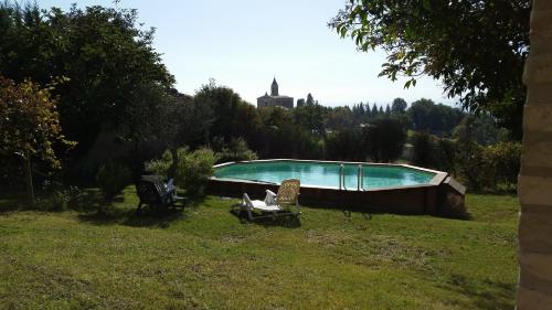 a swimming pool in a field with chairs in a yard at La Panoramica in Avenale