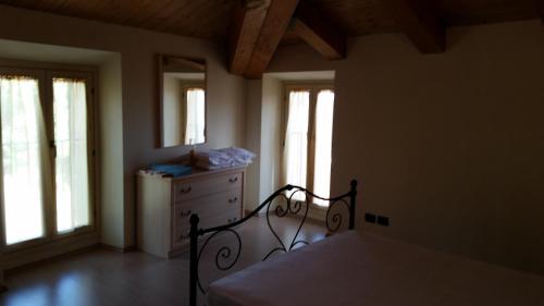 a bedroom with a bed and a dresser and windows at La Panoramica in Avenale