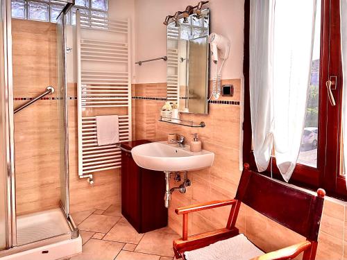 a bathroom with a sink and a shower and a chair at La Chicca di Francesca in Santa Teresa Gallura