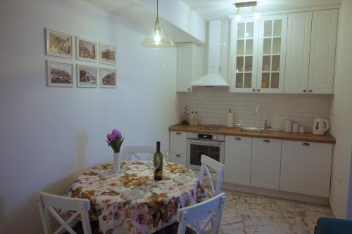 een keuken met een tafel en een fles wijn bij Amellia in Ljubuški