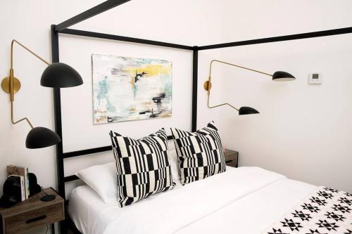 a bedroom with a black and white bed with two pillows at The Studio on Ast., Downtown Bentonville near all! in Bentonville