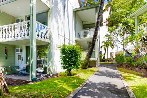 a building with a balcony and a sidewalk at Kona Islander Inn 112 in Kailua-Kona