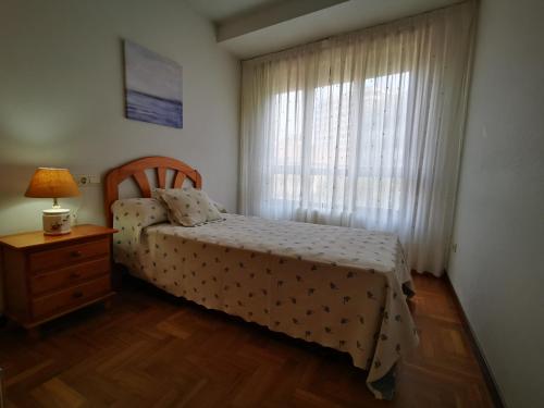 a bedroom with a bed with a dresser and a window at Apartamento Centro Gijón in Gijón