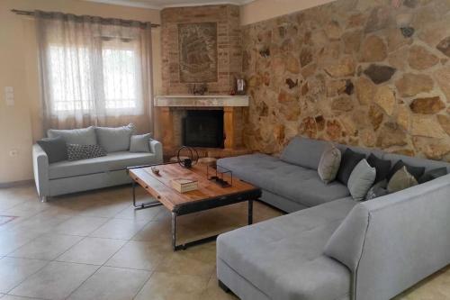 a living room with couches and a stone wall at Nikos House Megara in Megara