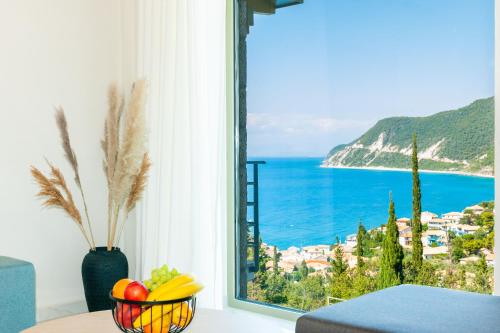 a bowl of fruit on a table in front of a window at Mylos Mountain Villas- Villa Giorgio in Agios Nikitas