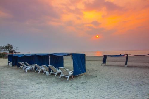 a group of chairs and a tent on the beach at Exclusive Apartasuites Reserva del Mar ツ in Gaira