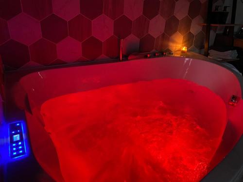 bañera roja llena de tinte rojo en Chambre chaleureuse avec jacuzzi, en Le Mesnil-en-Vallée