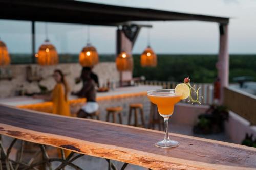 a drink sitting on top of a wooden table at Xkeban Tulum Adults Only in Tulum