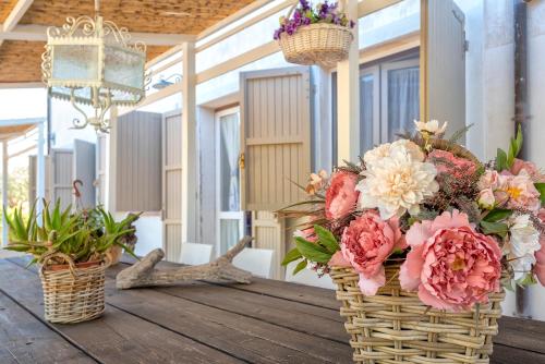 two baskets filled with flowers on a wooden table at Lu Casal de Fiò in Alghero