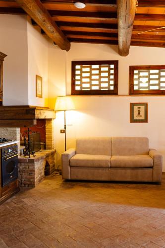 a living room with a couch and a fireplace at Podere Mezzastrada - Place of Charme in Fiano