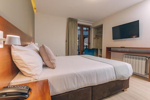 a hotel room with a large bed with a television at Saska Boutique Hotel in Cusco