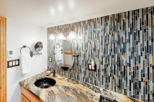 een badkamer met een wastafel en een spiegel bij Grand Avenue Retreat in Bozeman