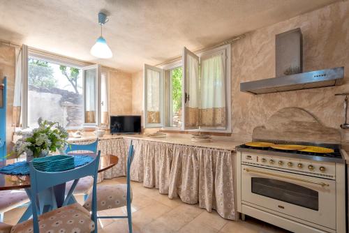 a kitchen with a table and a stove top oven at Lu Casal de Fiò in Alghero