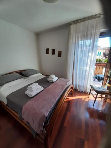 a bedroom with a bed and a window and a chair at La casa di Walter e Rosa in Castel di Sangro