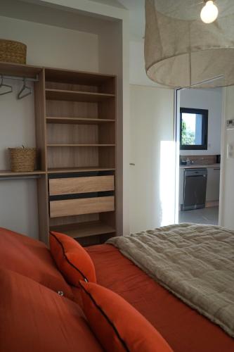 Cet appartement comprend une chambre avec un lit orange et une cuisine. dans l'établissement Maison chaleureuse en Provence, à Piolenc