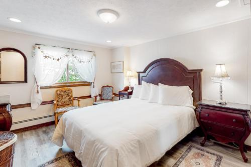 um quarto com uma grande cama branca e uma janela em Seaside Haven em Old Orchard Beach