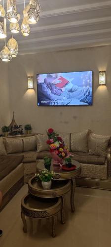 a living room with a couch and a table and a tv at Dar Malika in El Jadida