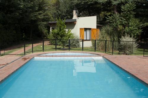una gran piscina azul frente a una casa en Cabañas La Morera en Villa Ventana