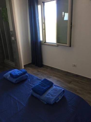 2 cuscini blu su un letto blu in una stanza di La Maison di Zia Annina in Sardegna a Olbia