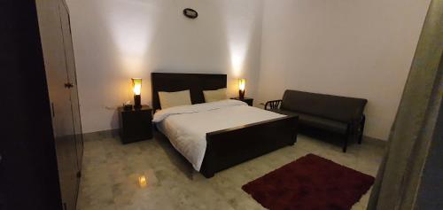 a bedroom with a bed and a chair at Stairway to Heaven in Murree