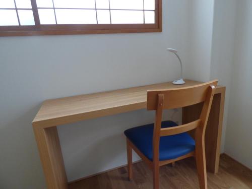 un escritorio de madera con una silla azul bajo una ventana en Kyoto City - Hotel - Vacation STAY 88891v, en Kioto