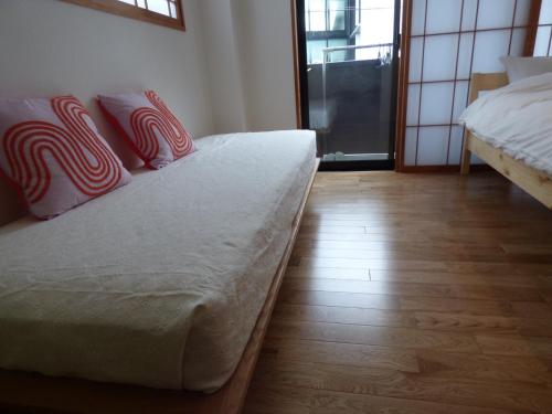 sypialnia z 2 łóżkami i białymi i czerwonymi poduszkami w obiekcie Kyoto City - Hotel - Vacation STAY 88891v w mieście Kioto