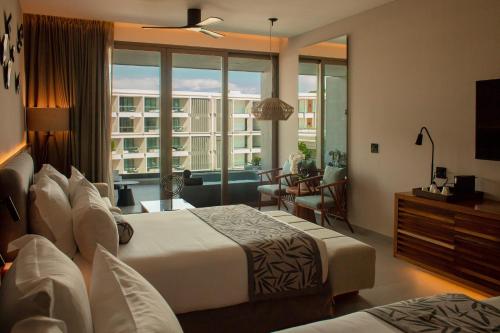 a hotel room with two beds and a large window at Dreams Bahia Mita Surf and Spa - All Inclusive in Punta Mita