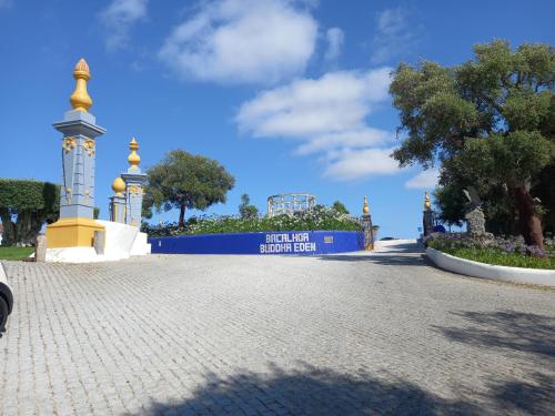 a building with a sign in the middle of a road at Murta's Home in Cadaval