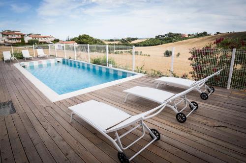 a deck with a swimming pool and two lounge chairs at Balconi Del Conero in Numana