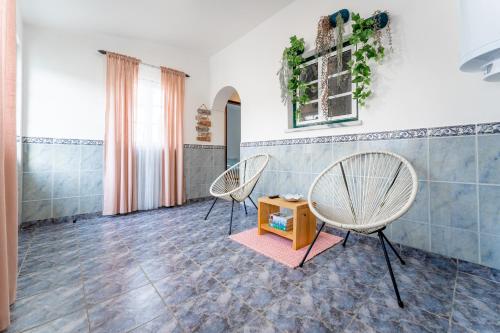 two chairs and a table in a room at Murta's Home in Cadaval